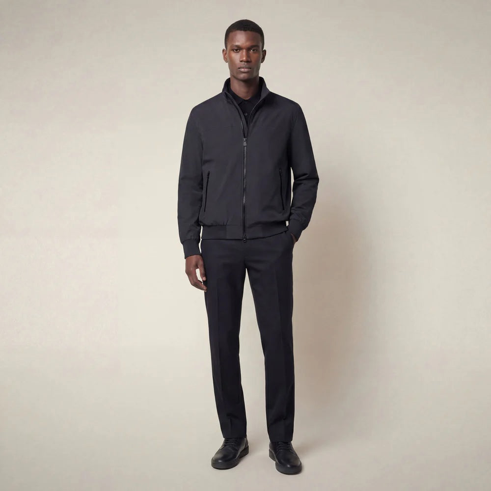 A man stands against a neutral background, wearing the SAVE THE DUCK - FINLAY JACKET IN BLUE BLACK with matching black shirt, trousers, and shoes. He has a neutral expression and his arms rest at his sides.