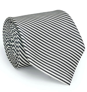 A rolled-up COLLARED GREENS - SIGNATURE STRIPE TIE IN BLACK by BIRD DOG BAY, handmade in New York from luxurious woven silk, featuring black and white diagonal stripes displayed against a white background.