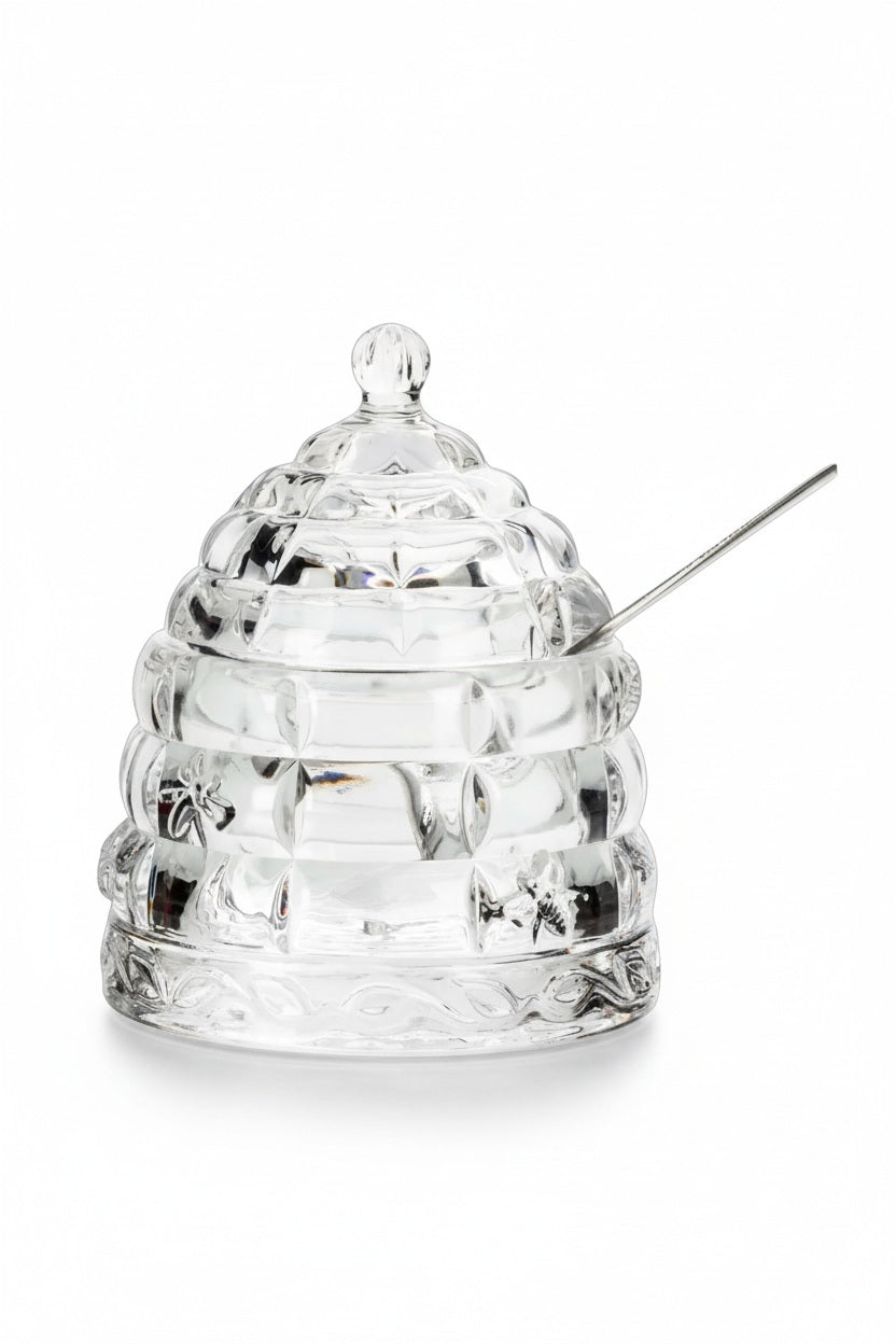 ABBOTT BEEHIVE HONEY POT WITH LID, a clear glass beehive-shaped pot with a matching lid and a silver honey dipper.