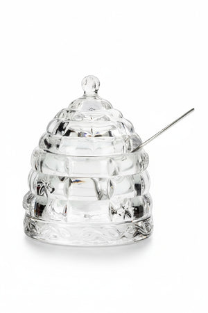 ABBOTT BEEHIVE HONEY POT WITH LID, a clear glass beehive-shaped pot with a matching lid and a silver honey dipper.