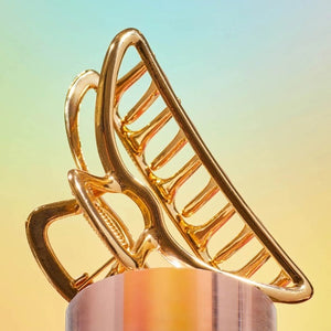 The KITSCH - OPEN SHAPE CLAW CLIP IN GOLD is a minimalist gold metal hair accessory from KITSCH, ideal for styling thick hair and showcased against a plain light background.