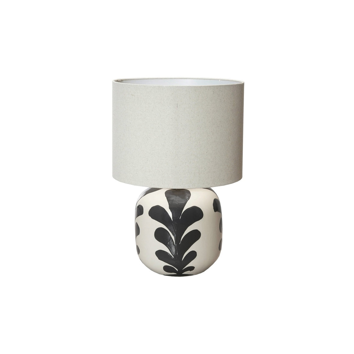 The CREATIVE COOP BLACK AND CREAM STONEWARE TABLE LAMP features a round ceramic base with black leaf designs and a light beige linen shade, set against a plain white background.