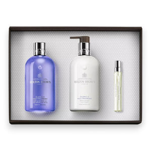 The MOLTON BROWN - BLUEBELL FRAGRANCE LAYERING GIFT SET features a Bluebell & Wild Strawberry body wash, a white lotion bottle with pump, and a slim fragrance spray—elegantly presented on a white textured background.