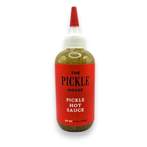 A clear squeeze bottle featuring a red label with “THE PICKLE HOUSE - PICKLE HOT SAUCE” from THE PICKLE HOUSE sits on a plain light background, filled with greenish sauce—this award-winning hot sauce blends tangy pickle brine and bold spices for a uniquely flavorful kick.