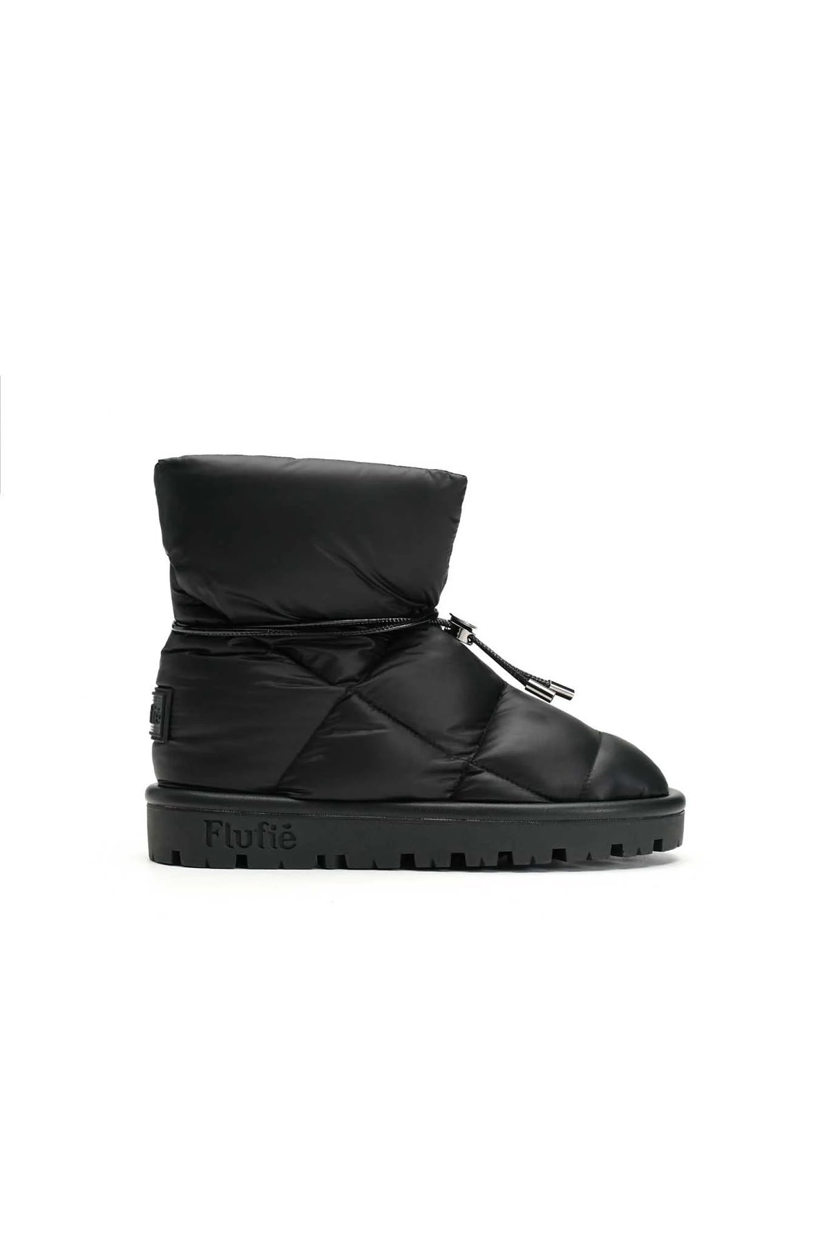 The METALLIC PILLOW BOOT by FLUFIE is a black, high-top winter boot with a padded, quilted design. It features a side zipper and a ridged sole, with the brand name "FLUFIE" embossed on the side of the sole. Insulated with goose down and boasting an anatomic insole, this boot is perfect for cold weather.