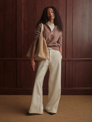 A person wearing a VARLEY - SHERIDA HALF-ZIP KNIT SWEATER IN GINGERBREAD FLECK, a brown speckled boucle yarn sweater with a collared half-zip neckline.