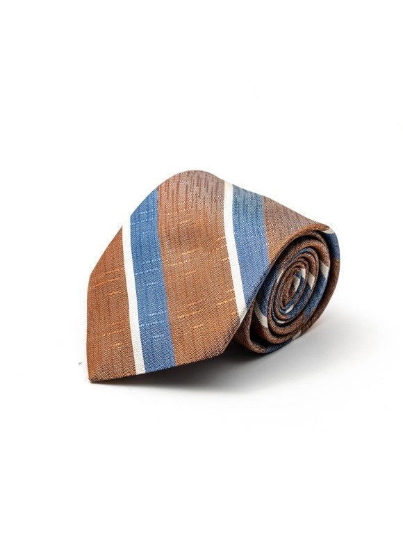 The EDWARD ARMAH - BAYADERE BROWN SUGAR STRIPE SILK TIE features wide blue and white bayadere stripes on a brown sugar base, displayed rolled up on a white background.