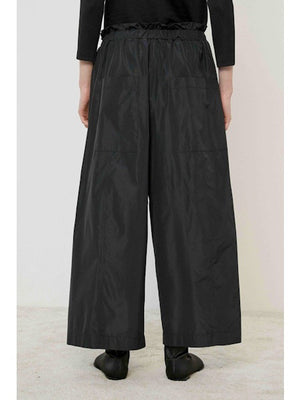 A flat, solid brown surface fills most of the image with a narrow black strip along the bottom edge, evoking the minimalist style of the MEIMEIJ - WIDE LEG PANT by MEIMEIJ.