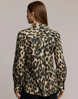 A woman with straight brown hair and gold hoop earrings is seen from the back, modeling the HINSON WU - MARGOT LONG SLEEVE SHIRT IN ANIMAL PRINT against a neutral background.