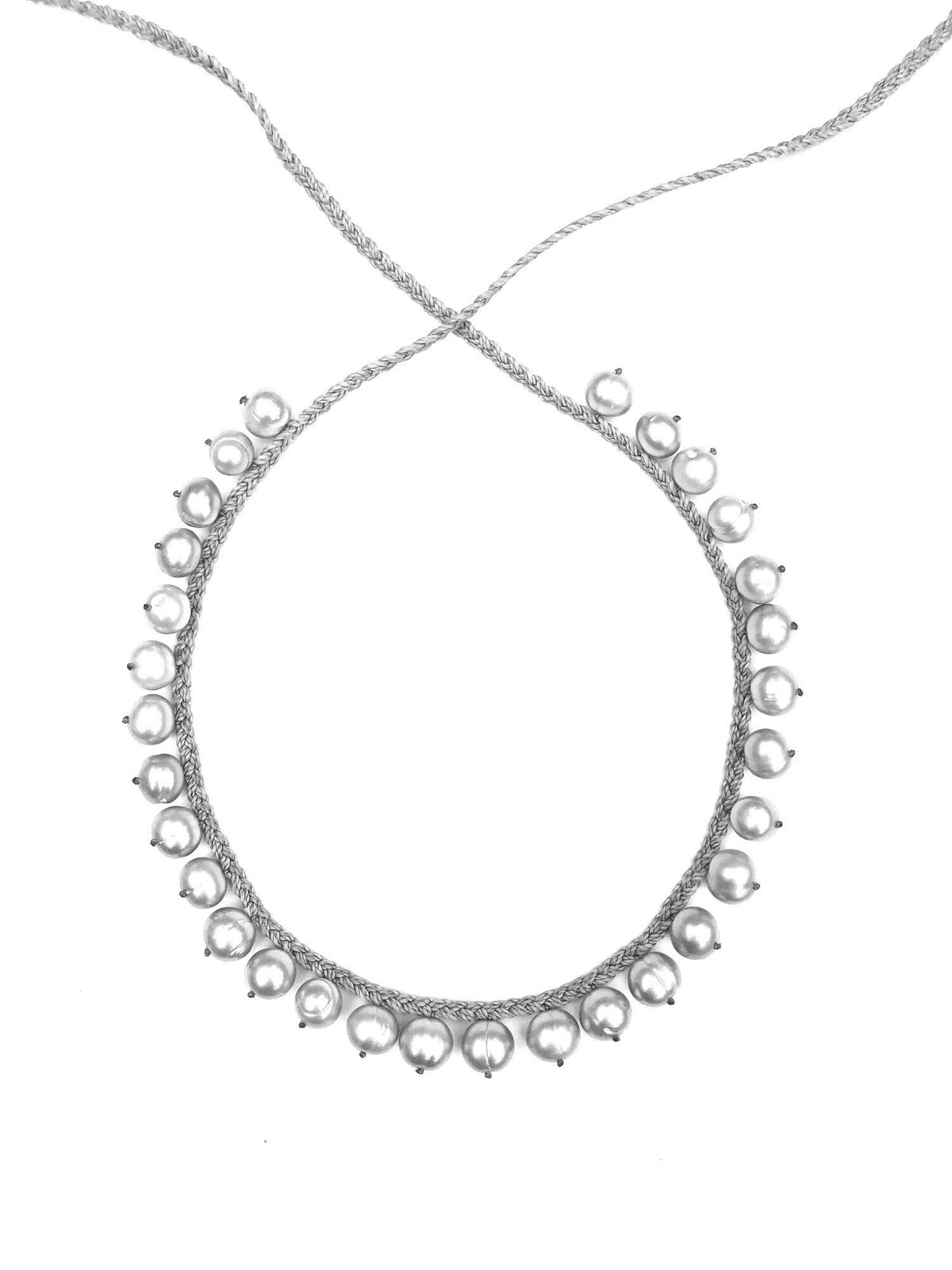 The ANN LIGHTFOOT - DEMI FRINGE PEARL NECKLACE by ANN LIGHTFOOT is a delicate silver fringe necklace with a braid-like chain, featuring evenly spaced spherical beads along its circumference. It captures a simple yet elegant design, exuding classic and minimalist appeal.