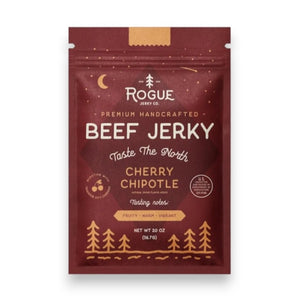 A maroon package of ROGUE JERKY CO. ROGUE JERKY - CHERRY CHIPOTLE BEEF JERKY, decorated with tree and mountain illustrations. The packaging highlights “Premium Handcrafted” and tasting notes of “Fruity, Warm, Vibrant.” This high-protein gourmet snack comes in a 2-ounce net weight.