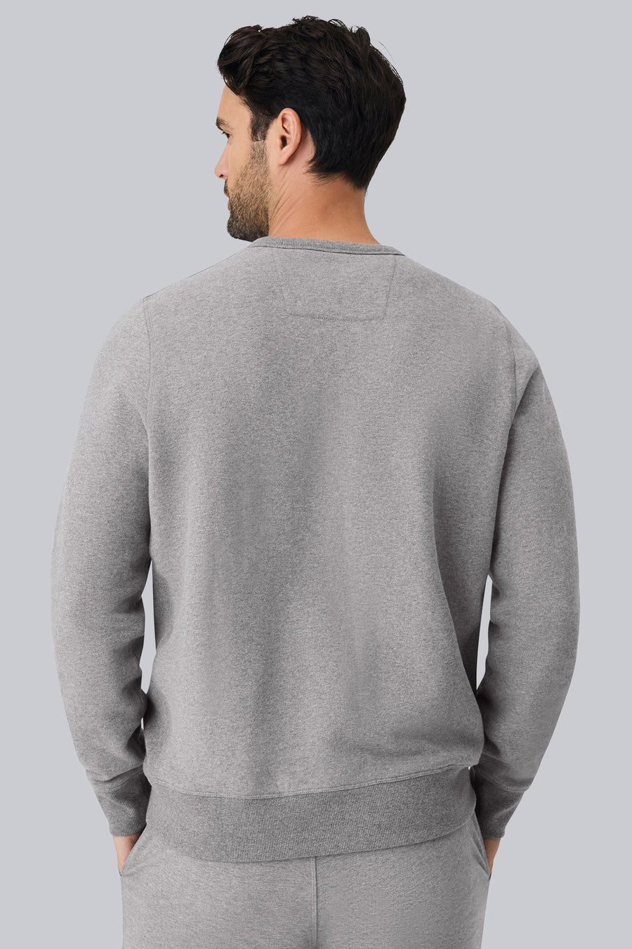The MACK WELDON Ace Crew Neck Sweatshirt in True Navy Bird’s Eye features long sleeves, a streamlined fit, navy ribbed trim, soft French terry fabric, visible stitching details, and a small label at the bottom hem.