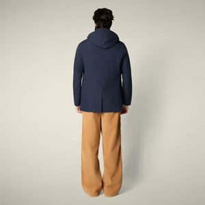 The SAVE THE DUCK - BENJAMIN Hooded Raincoat in Blue Black is a men's lightweight waterproof jacket made from recycled polyester, featuring a button-down front and classic design. Displayed on a plain light beige background.