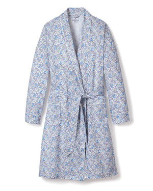 The PETITE PLUME - FLEUR D'AZURE ROBE by PETITE PLUME is a knee-length, long-sleeved bathrobe adorned with a vintage-inspired floral print in blue and white hues. Crafted from the finest quality cotton, the robe features a shawl collar and includes a matching fabric belt tied at the waist. It offers a relaxed fit ideal for comfortable lounging in luxurious sleepwear.