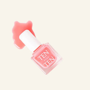 A glass bottle of TENOVERTEN - NAIL POLISH from the brand TEN OVER TEN, featuring a white cap and a dusty pink nail color. The front label displays "TEN OVER TEN" in white uppercase letters. This vegan, eight-free formula ensures both beauty and peace of mind. The background is plain and light-colored.