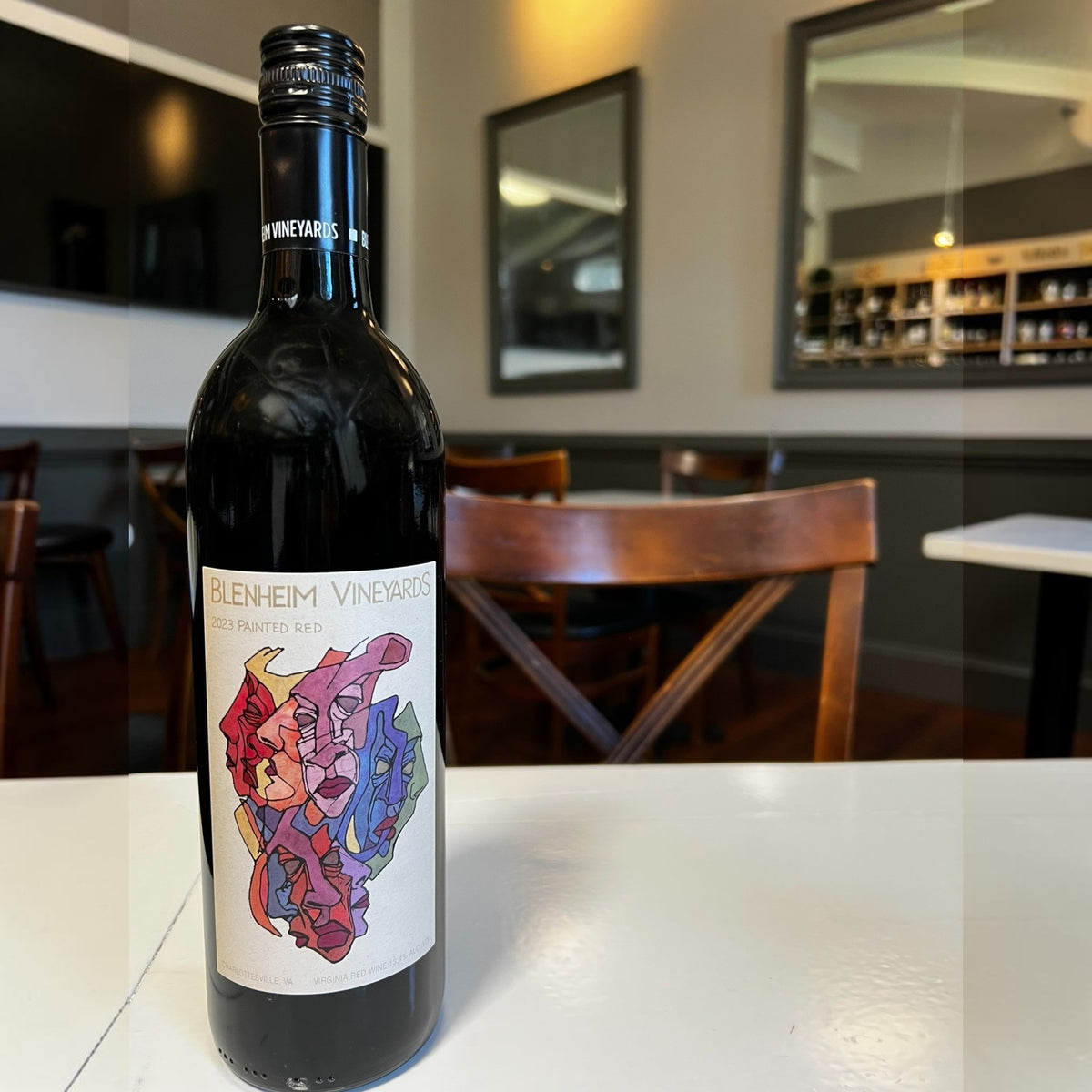 A bottle of BLENHEIM ‘PAINTED RED’ 2023 by WINE: 3 KEYS, featuring a colorful abstract label with red, blue, and yellow shapes on a light background.