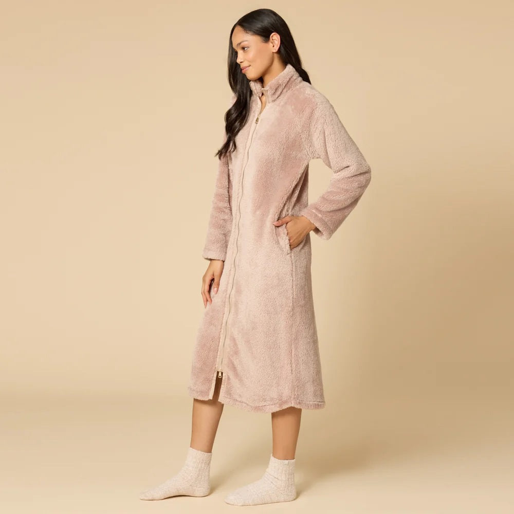 A woman wearing a blush-colored SOFTIES - DREAMPLUSH ZIP ROBE with matching knit socks.