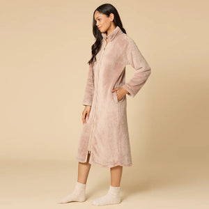A woman wearing a blush-colored SOFTIES - DREAMPLUSH ZIP ROBE with matching knit socks.