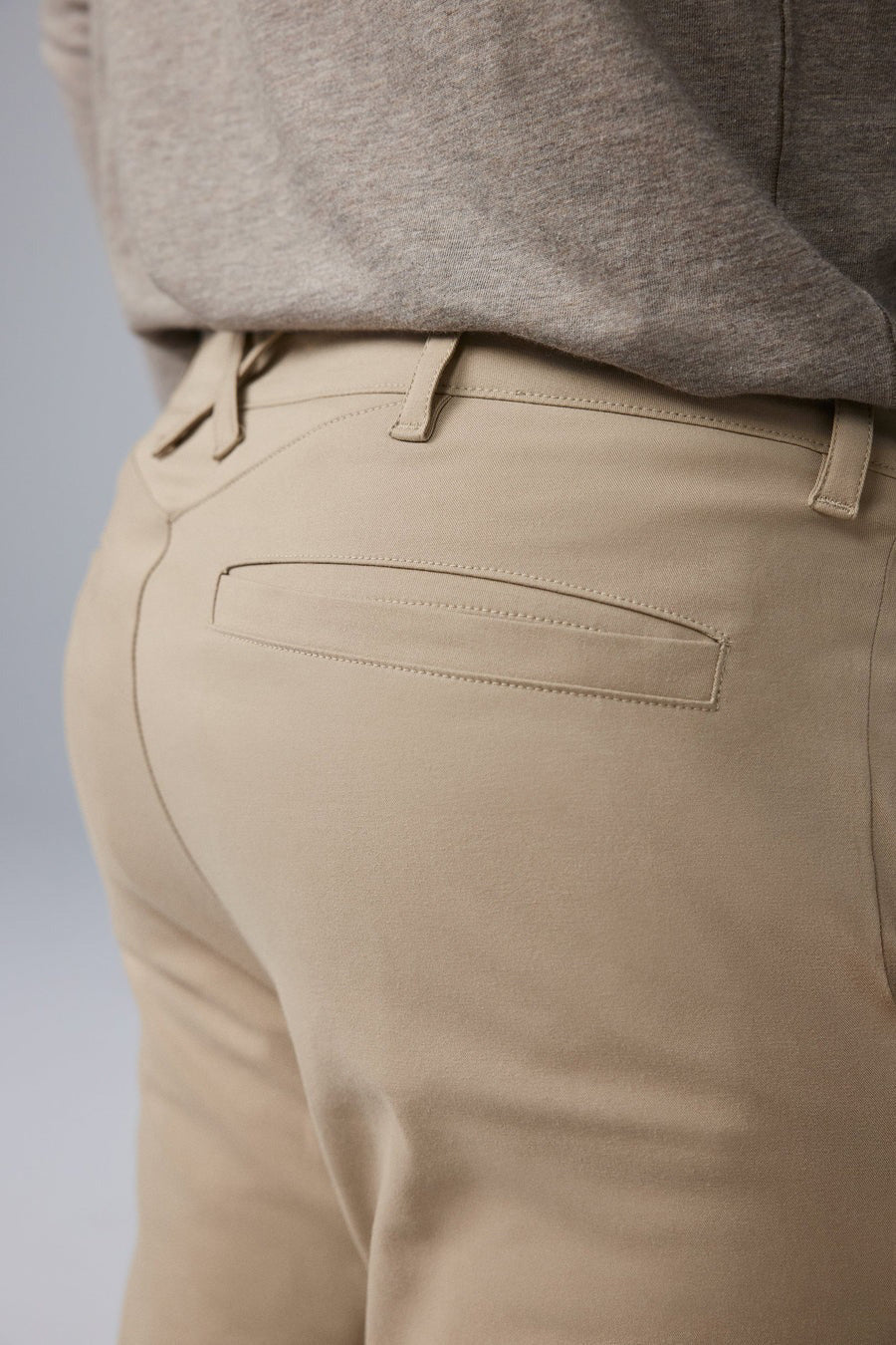 The MACK WELDON - MAVERICK TECH CHINO is a beige, stain-resistant pair of chinos with a straight-leg cut, button closure, and side pockets, shown laid flat on a white background.