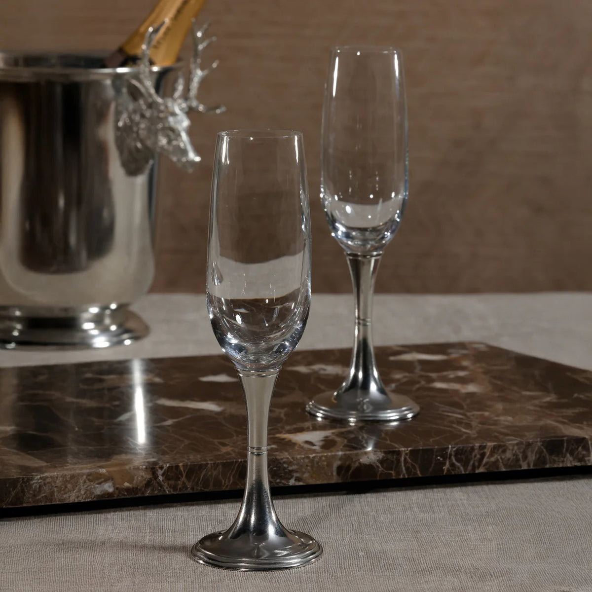 The ZODAX ST. MORITZ Pewter and Glass Champagne Flute features a clear bowl with a silver-tone metal stem and base, photographed on white, and is ideal for serving sparkling wine from 210 ml bottles or other small containers.