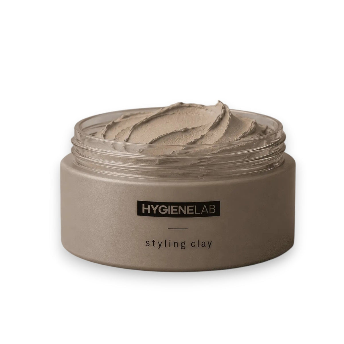 An open, round container of HYGIENELAB - STYLING CLAY displays the smooth, light gray clay inside with a swirled surface. This styling clay from HYGIENELAB provides a medium-strong hold and a natural matte finish.