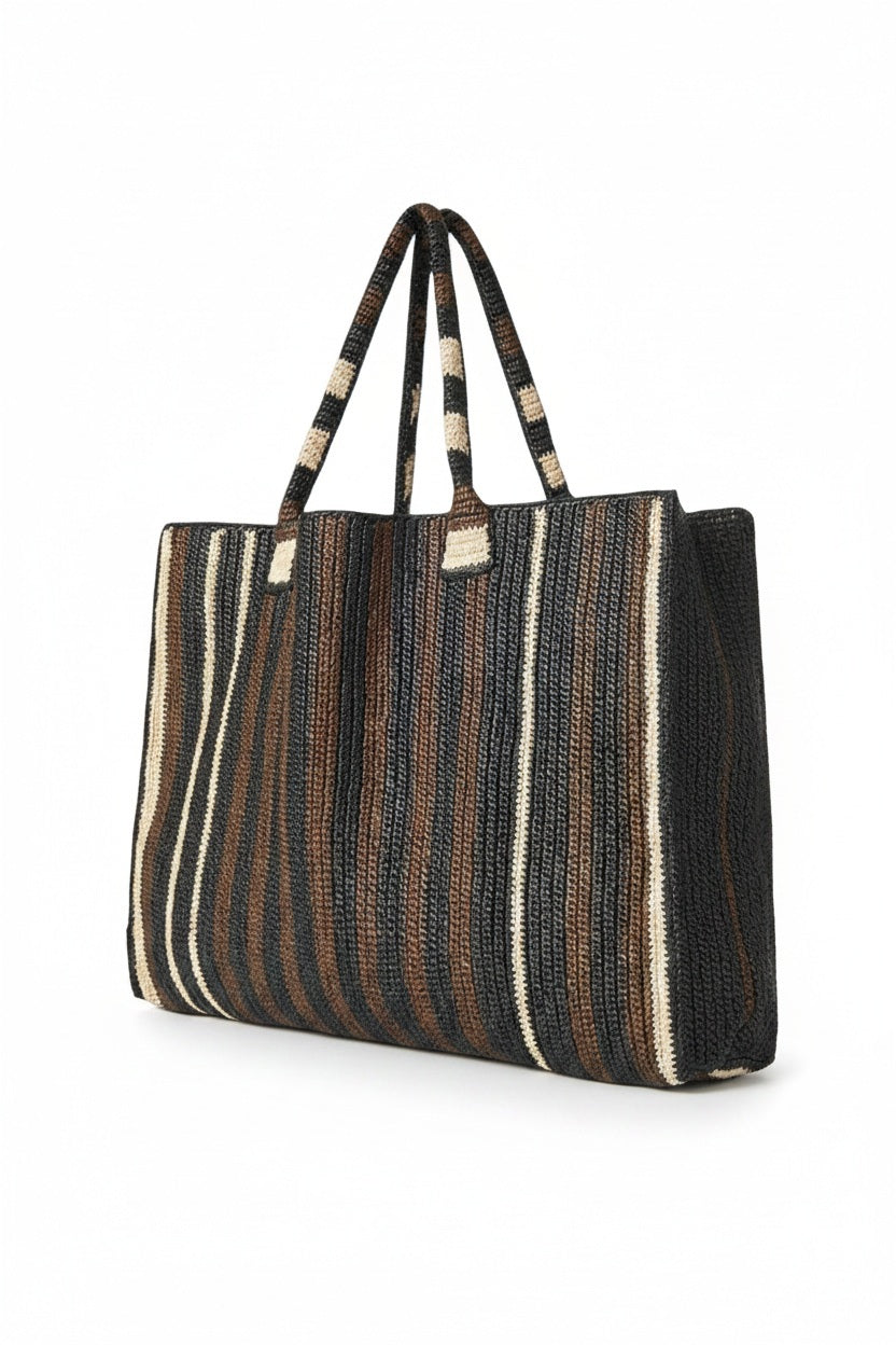 The GABRIELE FRANTZEN Little Sister Weekender Bag in Nomad features a spacious rectangular design with two handles and black, brown, and beige vertical stripes on white—ideal for stylish weekend getaways.