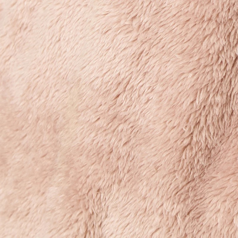 A woman wearing a blush-colored SOFTIES - DREAMPLUSH ZIP ROBE with matching knit socks.