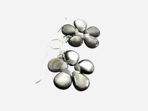 The ANN LIGHTFOOT – FLOWER EARRINGS OF BLACK LIP SHELL feature five dark iridescent teardrop stones in a floral pattern with silver wire accents, displayed against a plain white background.