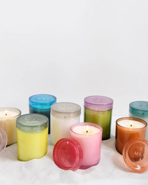 The MERSEA - SUMMER IN PROVENCE JOLIE JAR CANDLE by MERSEA features a green glass jar with a translucent pink lid, shown on a white background. Its smooth, cylindrical design makes it ideal for holding summer-inspired scents.