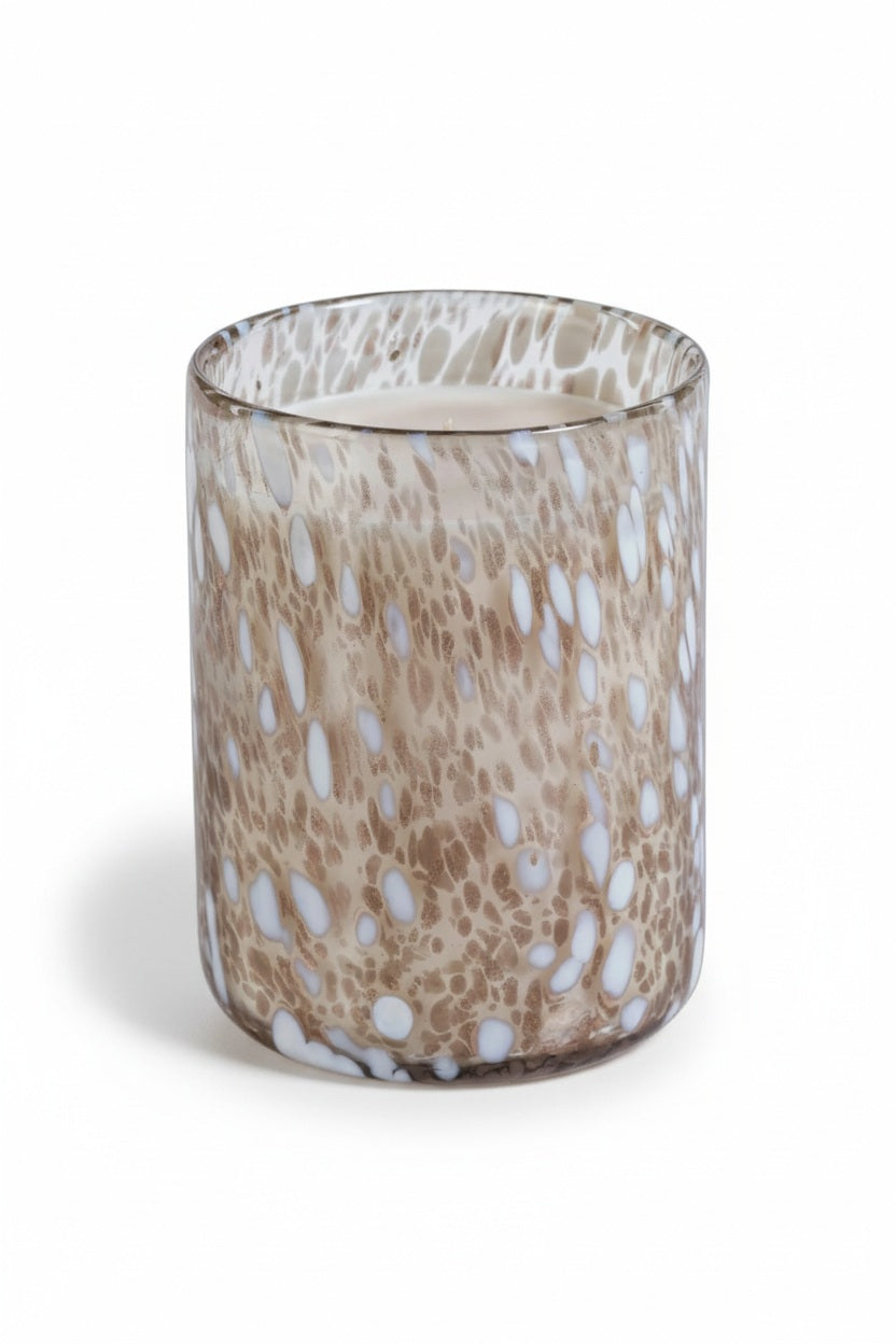 SPECKLED LUMINA TONKA ABSOLUTE SCENTED CANDLE 21.5OZ cylindrical glass candle holder featuring a brown and white speckled pattern.