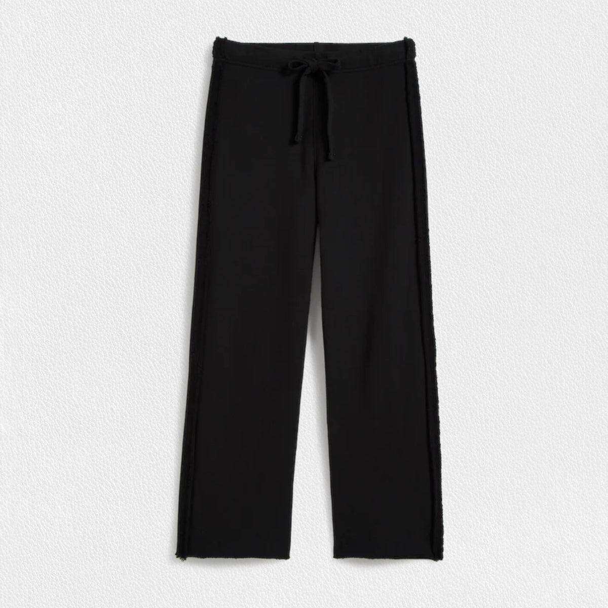 A pair of FRANK &amp; EILEEN - BELLA ITALIAN SWEATPANT IN BLACK from FRANK &amp; EILEEN featuring a mid-rise drawstring waist. The pants have a straight-leg cut with a slightly loose fit and a clean hem at the bottom. Made from Triple Fleece fabric, they appear smooth and comfortable, perfect for casual wear. The background is a plain white textured surface.