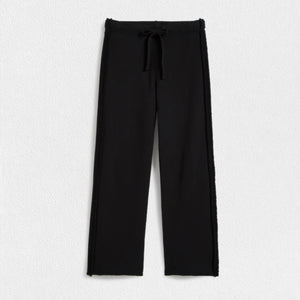 A pair of FRANK & EILEEN - BELLA ITALIAN SWEATPANT IN BLACK from FRANK & EILEEN featuring a mid-rise drawstring waist. The pants have a straight-leg cut with a slightly loose fit and a clean hem at the bottom. Made from Triple Fleece fabric, they appear smooth and comfortable, perfect for casual wear. The background is a plain white textured surface.