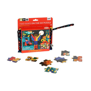 The image shows the packaging of the SUPERHERO DOUBLE SIDED ON THE GO PUZZLE by PETITECOLLAGE, ideal for ages 5+. It contains 49 pieces and is packaged in a vibrant, portable carrying case decorated with heroic characters. Warning: small parts included.