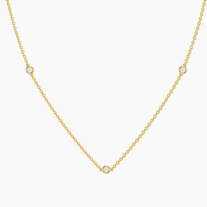 The ELLA STEIN - DOT TO DOT NECKLACE by ELLA STEIN is a delicate gold plated piece featuring a fine chain adorned with three evenly spaced small round natural diamonds, beautifully showcased on a white background. This elegant necklace brings a touch of sophistication to any outfit.