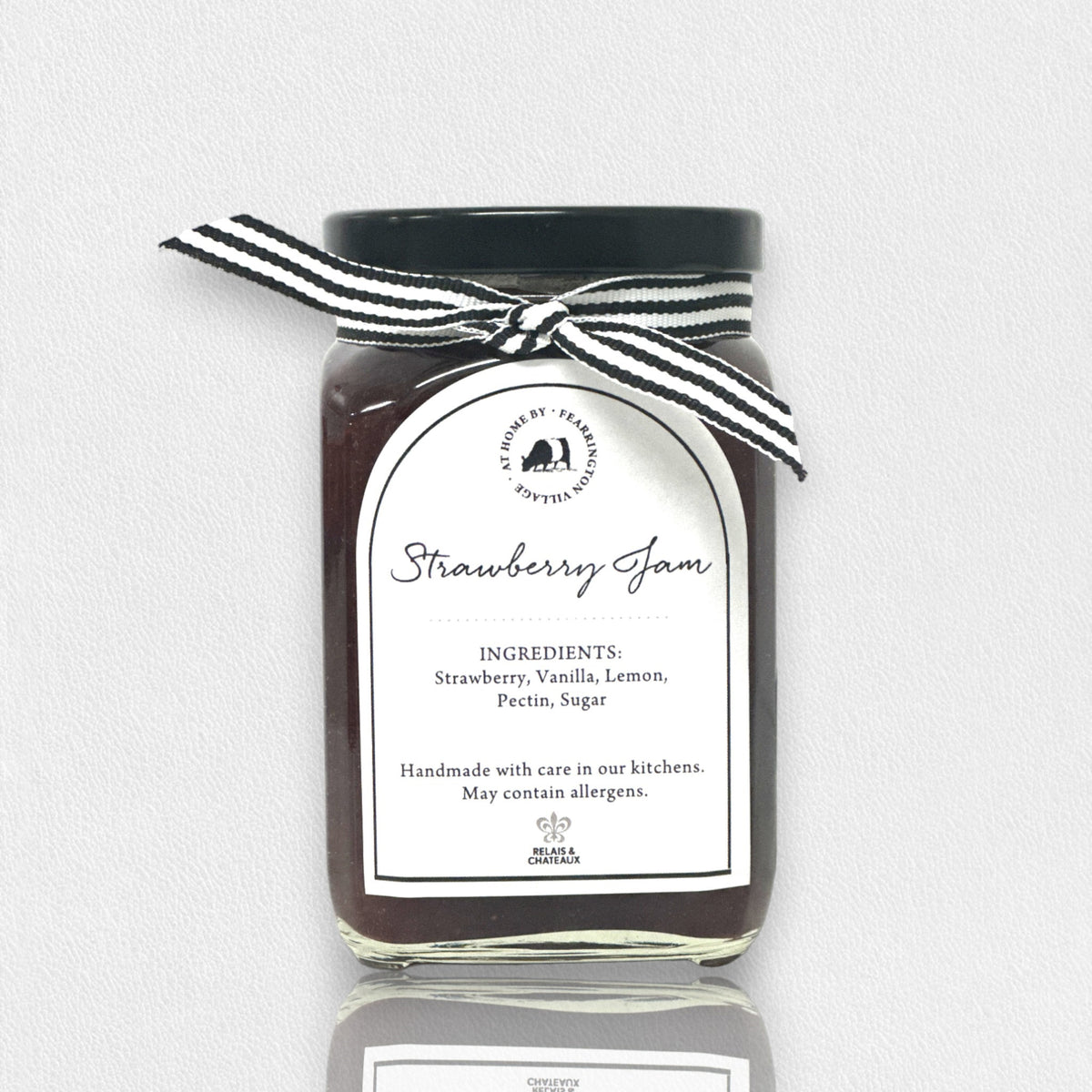 Introducing the FEARRINGTON HOUSEMADE STRAWBERRY JAM from the FEARRINGTON SIGNATURE COLLECTION, this jar of delicious strawberry jam is adorned with a charming black and white striped ribbon tied around the lid. Perfect as a hostess gift, its label lists wholesome ingredients such as strawberry, vanilla, lemon, pectin, and sugar. This handmade treat may contain allergens and is a delightful choice for breakfast jam enthusiasts.