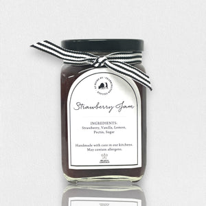 Introducing the FEARRINGTON HOUSEMADE STRAWBERRY JAM from the FEARRINGTON SIGNATURE COLLECTION, this jar of delicious strawberry jam is adorned with a charming black and white striped ribbon tied around the lid. Perfect as a hostess gift, its label lists wholesome ingredients such as strawberry, vanilla, lemon, pectin, and sugar. This handmade treat may contain allergens and is a delightful choice for breakfast jam enthusiasts.