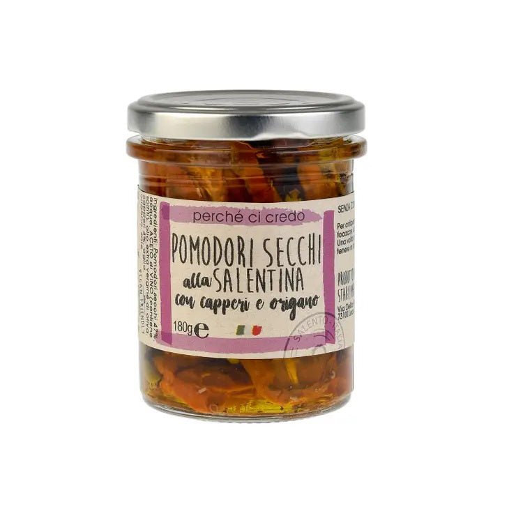 A glass jar filled with sun-dried tomatoes labeled "PERCHE CI CREDO - SUN-DRIED TOMATOES" on a white background. The jar has a metal lid and contains 180 grams of tomatoes with capers and oregano infused in extra virgin olive oil. The brand name "ZIA PIA IMPORTS" is featured on the label.