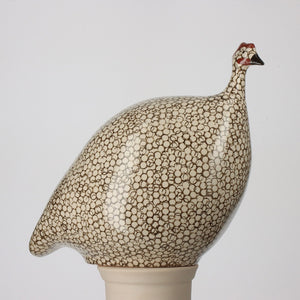 Four large ceramic pecking French guinea fowl in white with black spots are displayed against a neutral background. The text "Les Céramiques de Lussan" appears at the top left corner, showcasing exquisite handmade pottery from France.