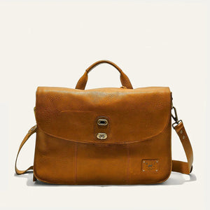 The WILL LEATHER GOODS Kent Messenger Bag in tan full-grain leather features a top handle, adjustable shoulder strap, front zip pocket, brass hardware, and laptop sleeve. Shown against a plain off-white background.