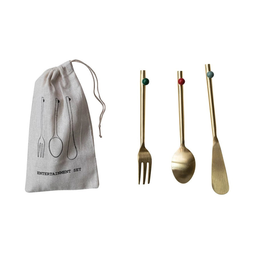 A cloth pouch labeled &quot;Entertainment Set&quot; with utensil sketches sits beside CREATIVE COOP&#39;s STAINLESS STEEL CUTLERY SET WITH ENAMELED BALL, featuring a fork, spoon, and spreader with colored enameled balls on the handles.