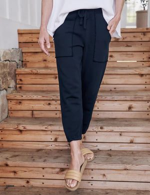 The FRANK & EILEEN Eamon Jogger Sweatpant in British Royal Navy features a stylish drawstring waistband, noticeable stitching on the two sizable front pockets, and fitted cuffs at the ankles. Constructed from 100% cotton, these sweatpants offer a soft and comfortable fabric that is perfect for both casual and athletic wear.