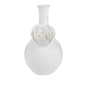 The CAMEO LONG NECK PORCELAIN BUD VASE by ZODAX is a round, white vase with a matte finish, featuring a narrow neck and a detailed floral embellishment on the front.