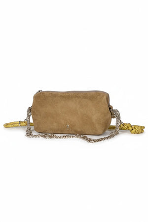 The CRAIE STUDIO - NUAGE SUEDE SEPIA MINI BAG, a compact brown suede shoulder bag featuring a zipper and a long yellow strap, is showcased on a white pedestal against a light background.