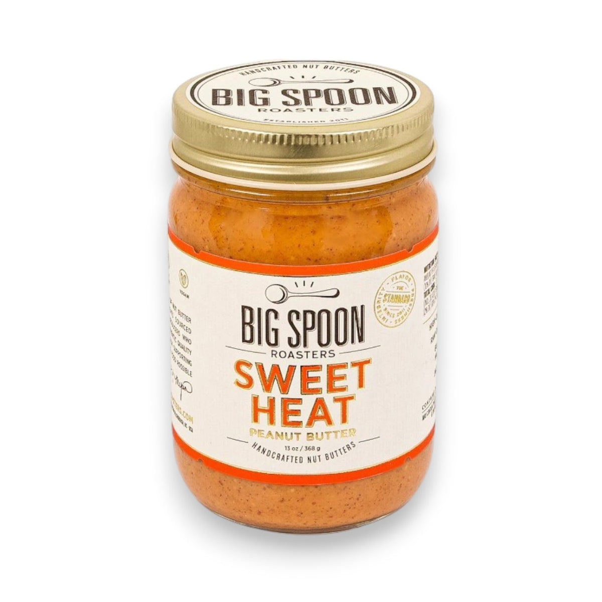A jar of BIG SPOON ROASTERS SWEET HEAT PEANUT BUTTER features an orange spread, gold lid, and white label with bold black and orange text—BIG SPOON ROASTERS’ twist on classic Haitian Mamba.