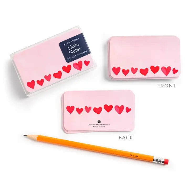The E. FRANCES - LITTLE NOTES BLUSH MINI HEARTS is a rectangular mini note card with a light pink background and red hearts in various sizes. "Little Notes® by E. FRANCES PAPER" and "Please recycle me." are printed at the bottom.