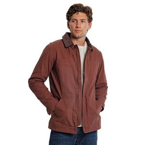 Close-up of the interior of a brown plaid CRIQUET - WAXED RANCH JACKET IN BOURBON, showing a white “Clubhouse Collection” brand label with a blank line for a player’s name.