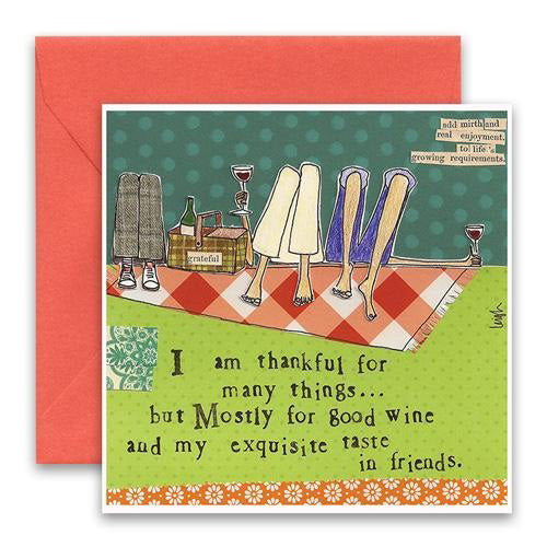 The CURLY GIRL DESIGNS - EXQUISITE TASTE GREETING CARD by CURLY GIRL DESIGN, INC features a whimsical illustration of three pairs of legs seated on a red-and-white checkered picnic blanket, accompanied with wine, cheese, and glasses. The charming text reads, "I am thankful for many things... but mostly for good wine and my exquisite taste in friends.