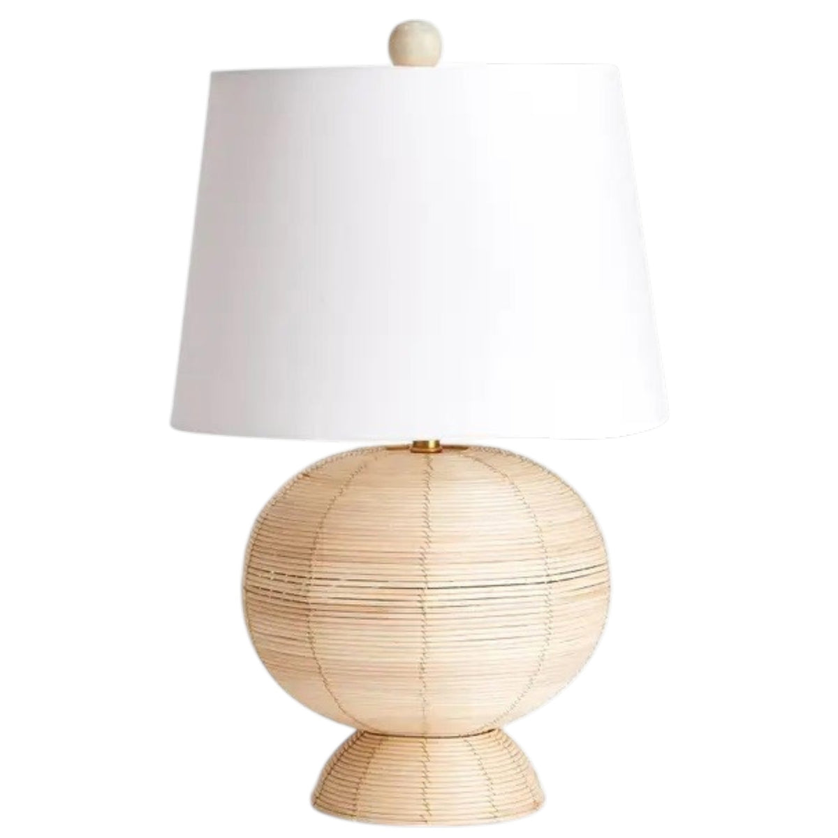The NAPA HOME AND GARDEN Maye Rattan Hourglass Lamp with Shade features a wicker-style base and white shade, casting a warm glow on any wooden surface.