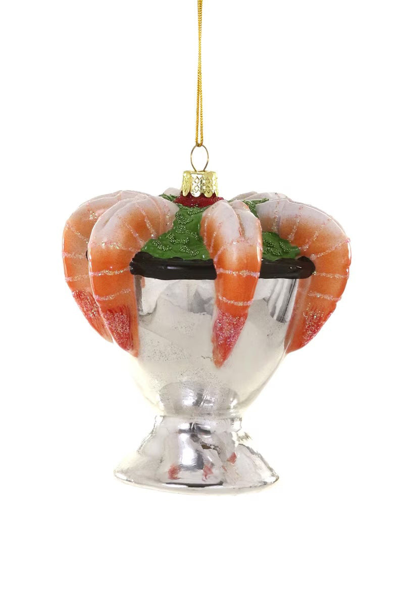 The SHRIMP COCKTAIL ORNAMENT by CODY FOSTER is a 3.5-inch glass decoration shaped like a silver shrimp cocktail dish with realistic shrimp and garnish, hanging from a gold string—perfect for adding whimsy to your holiday décor.