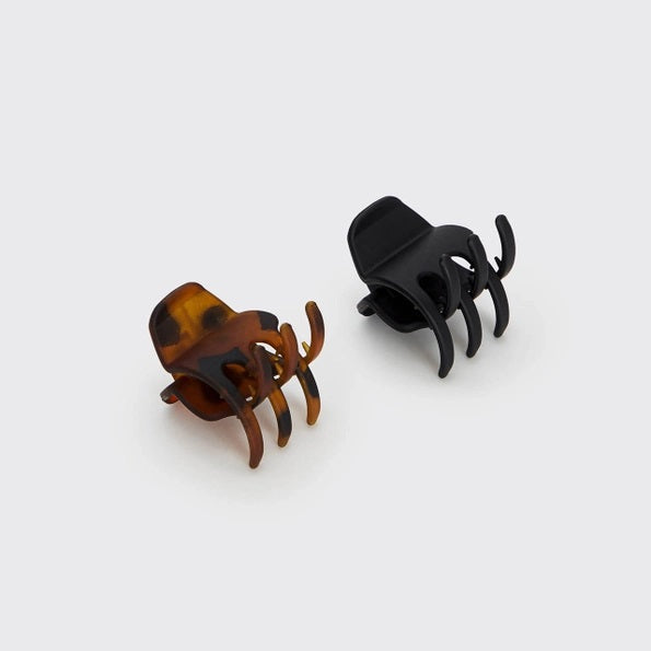 The KITSCH - ECO FRIENDLY MEDIUM CLAW CLIP, 2 PIECE SET features two medium-sized claw clips—one black and one tortoiseshell—secured on a cream “KITSCH” branded card labeled “Claw Clips.” Made from recycled materials, these eco-friendly clips are designed for comfortable all-day hold.